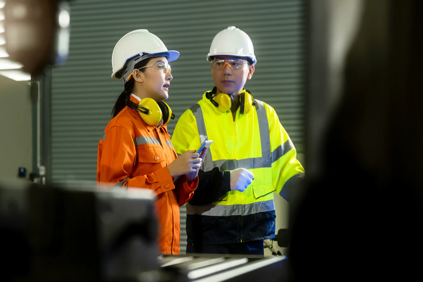 Two engineers reviewing factory systems with a tablet