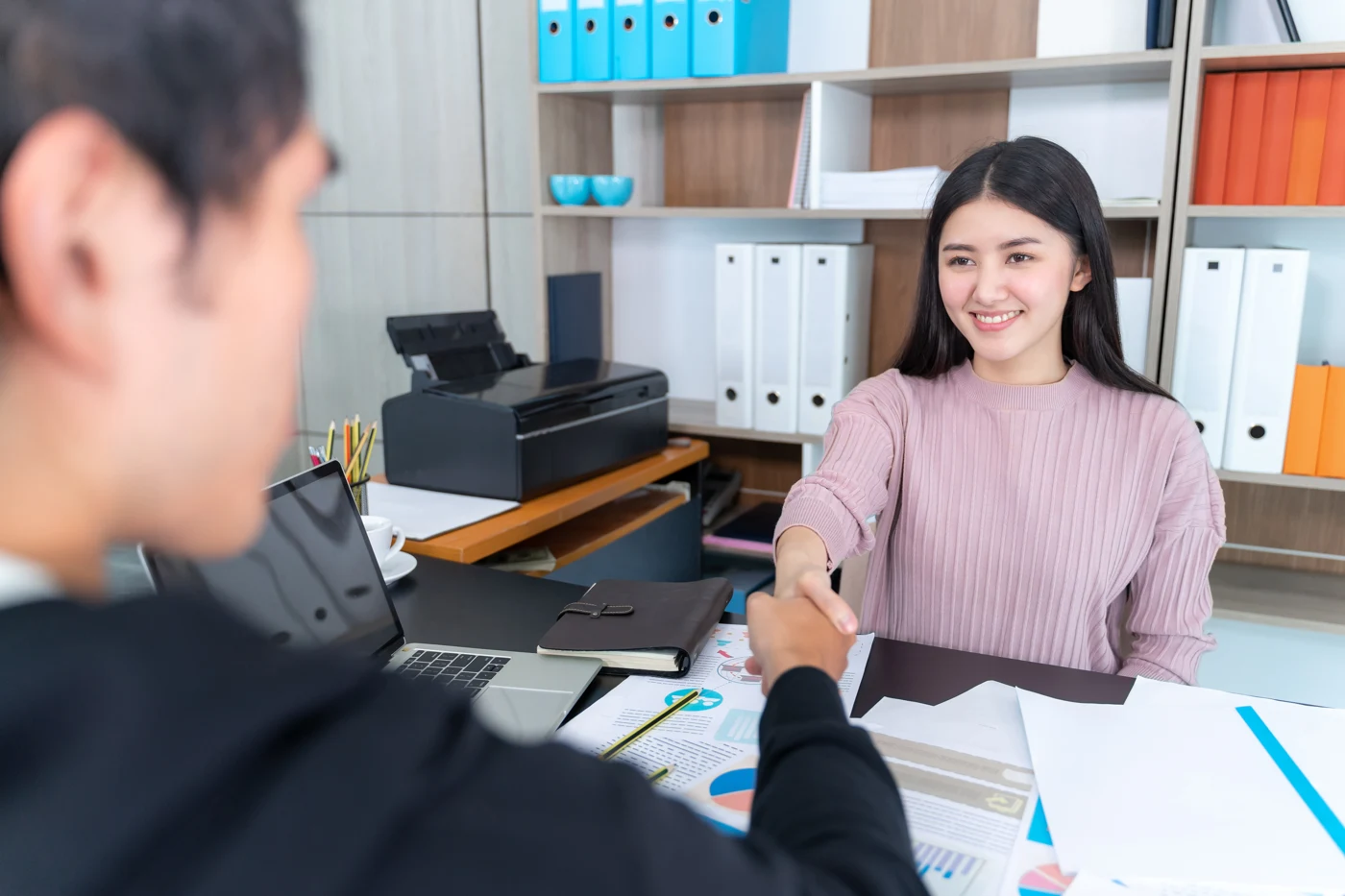 Professional welcoming a customer during an office meeting