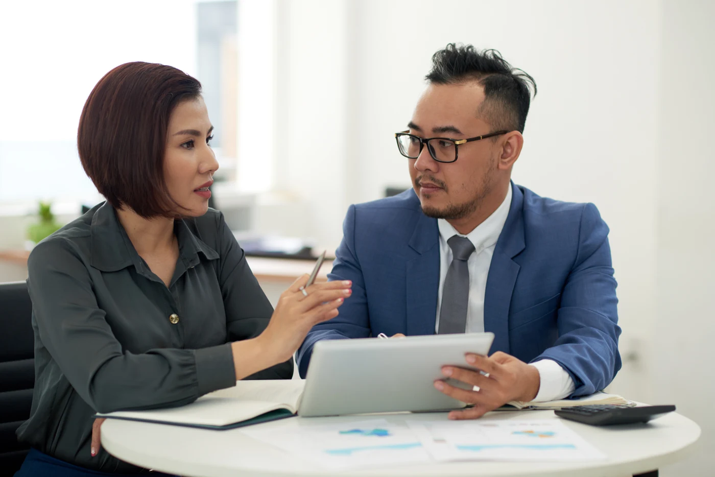 Two financial professionals reviewing information on a tablet