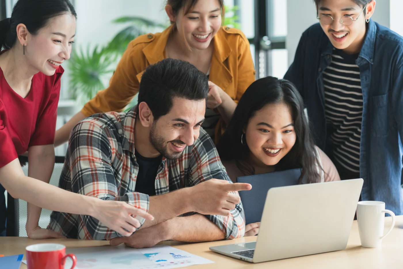 Startup colleagues collaborating around a laptop