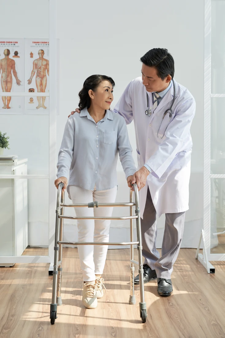 Physiotherapist supporting a patient during a rehabilitation appointment