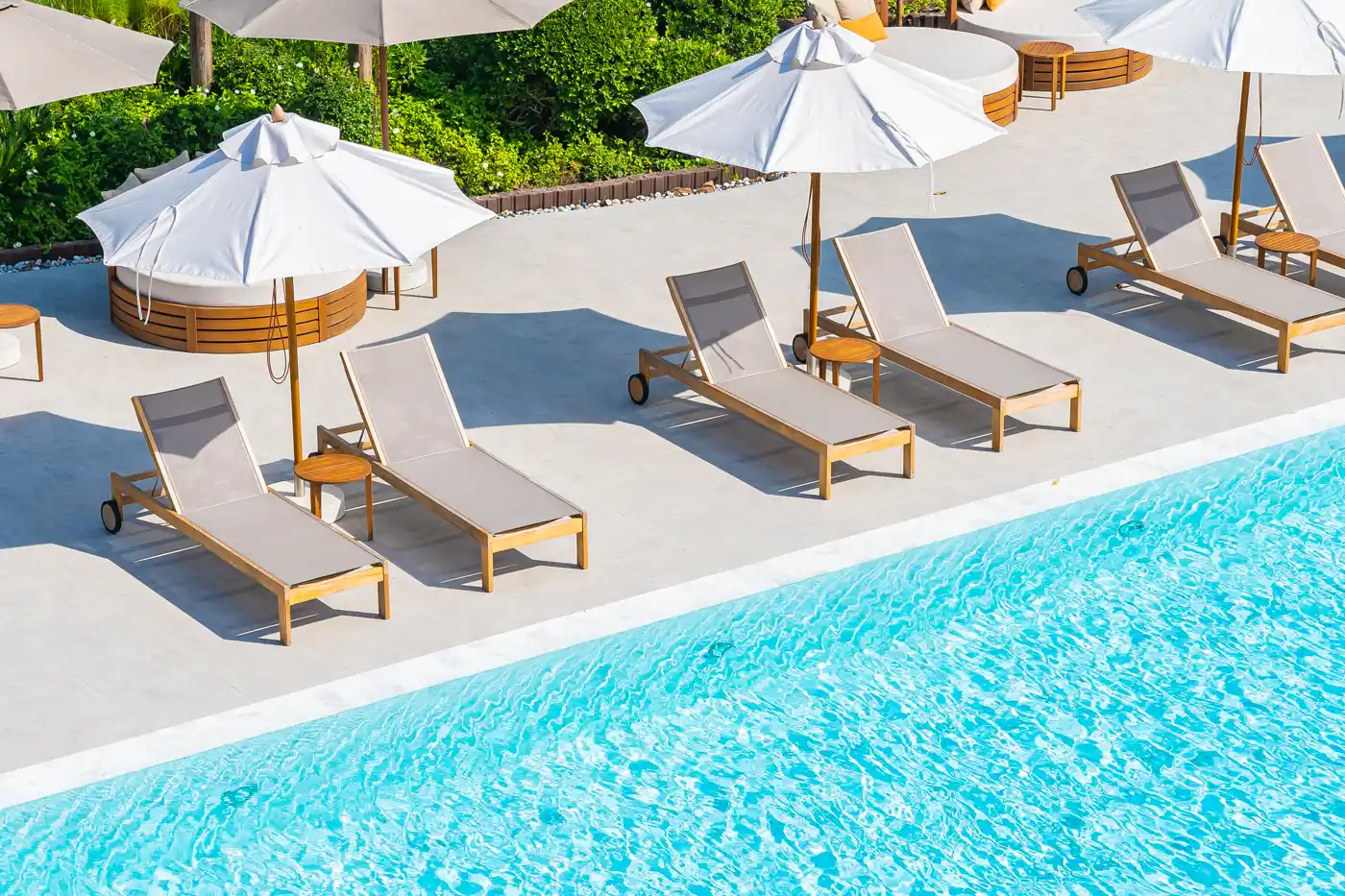Resort swimming pool with sun loungers and umbrellas