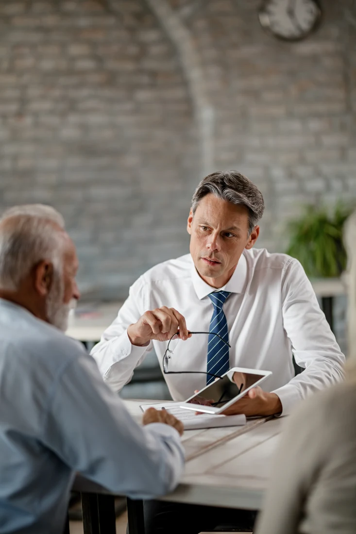 Insurance adviser explaining information to customers using a tablet
