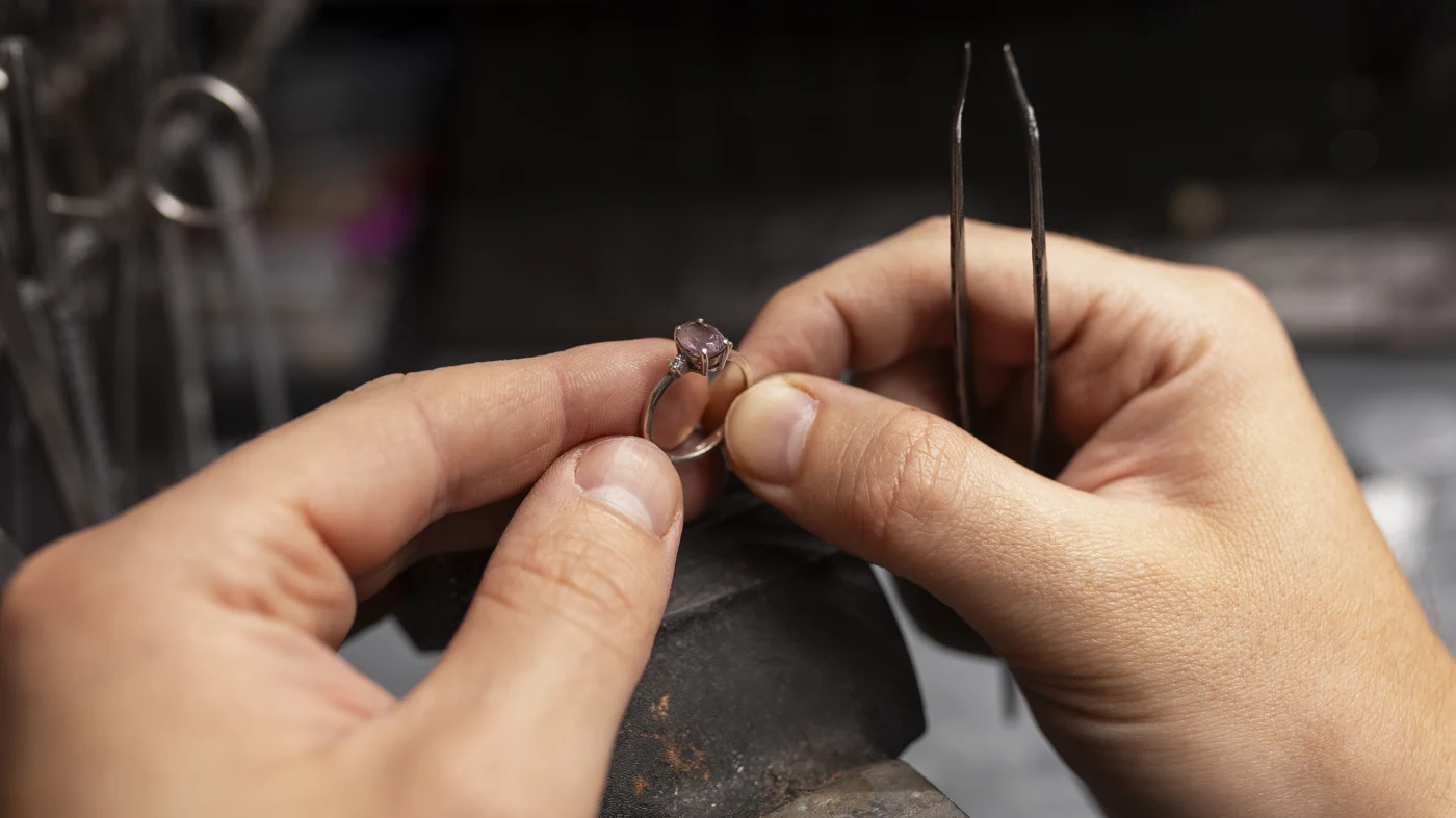 Jeweler carefully working on a gemstone ring by hand