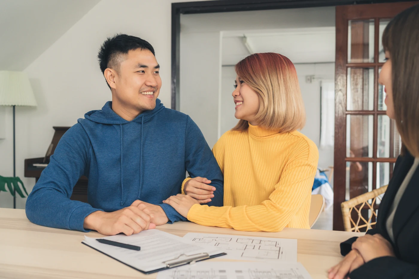 Asian couple discussing property plans with a real estate adviser