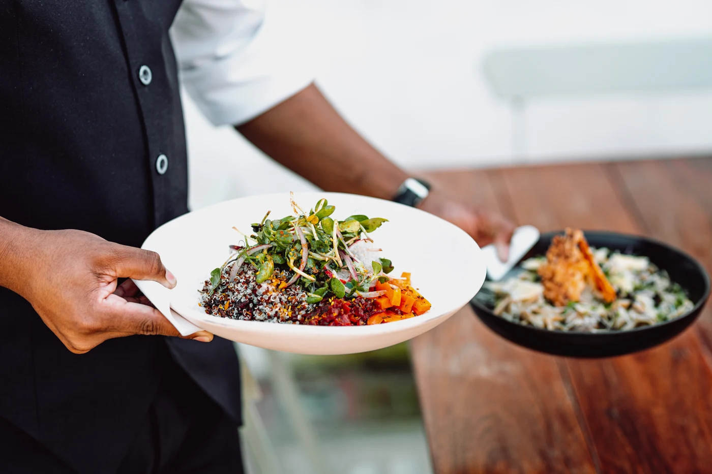Waiter serving colourful dishes at a restaurant