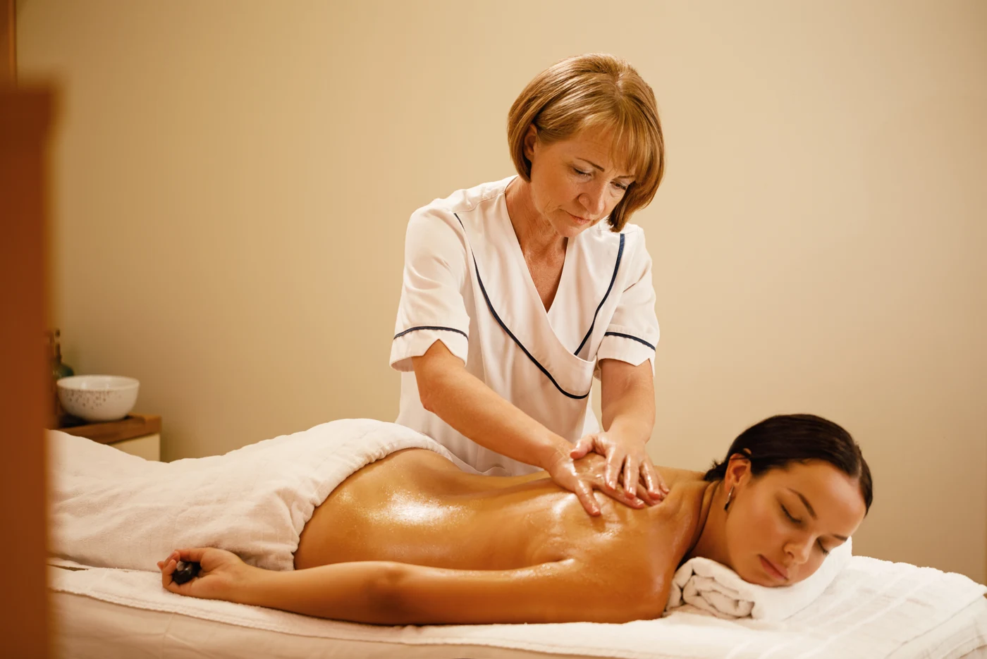 Professional spa therapist providing a relaxing back massage